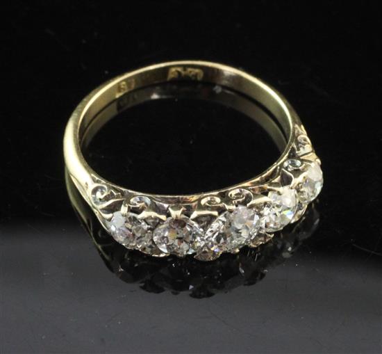 An early 20th century 18ct gold and graduated five stone diamond half hoop ring, size M.